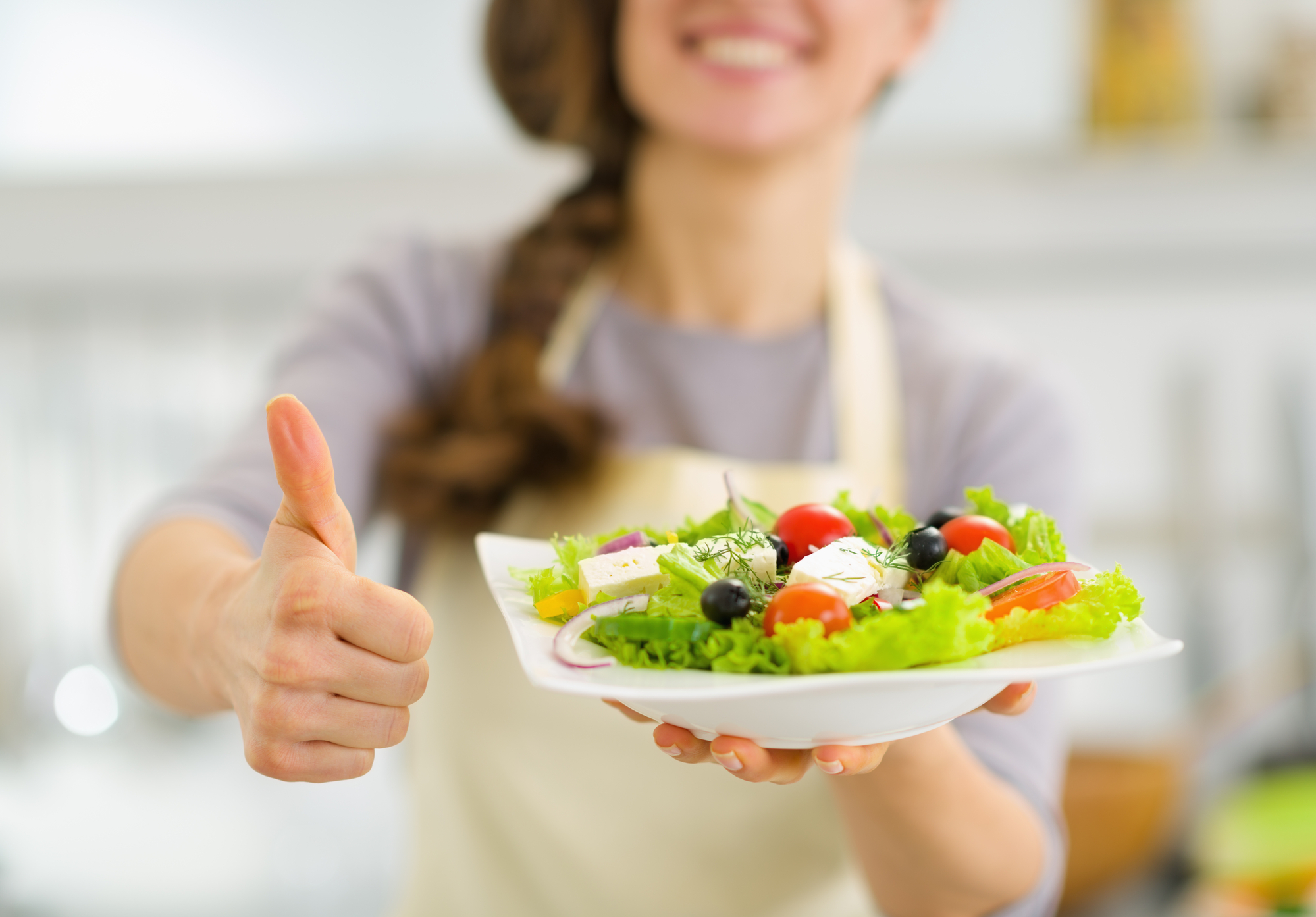 A woman serving a plate of salad